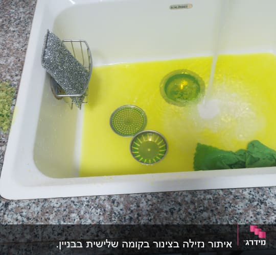 כיור עם מים צהובים, מסננים וספוג מתכת